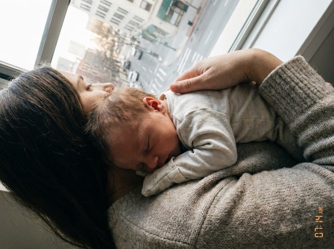 Une photo de nourrisson prise à contre-jour devant une fenêtre